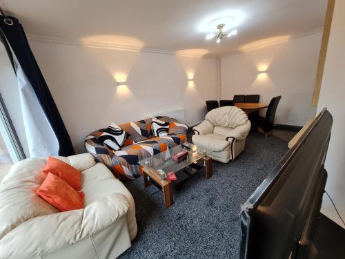 a living room with two couches and a table at 2-Bed House Bungalow in Bristol in Bristol