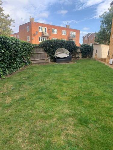 a backyard with a mattress in the grass at Large Luxury appartment in Cobham