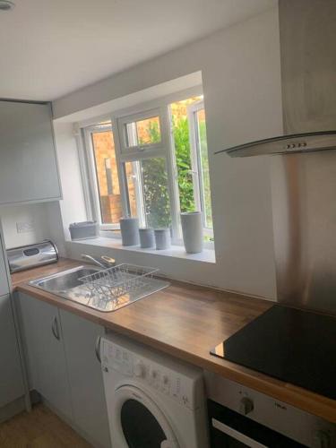 a kitchen with a sink and a washing machine at Large Luxury appartment in Cobham