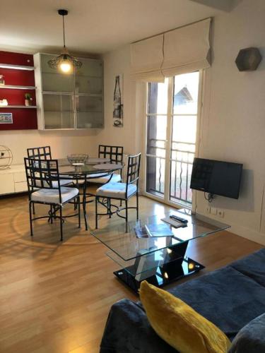un salon avec une table, des chaises et une télévision dans l'établissement Duplex Du Cottage, à Honfleur