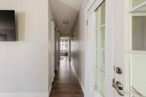 a hallway with white walls and wood floors and a window at Cute downtown home by Depot Park in Gainesville