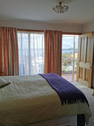 a bedroom with a bed and a large window at Flinders Island Masters Quarters - Lady Barron in Lady Barron