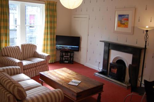 sala de estar con chimenea y TV en Royal Mile Cranston, en Edimburgo