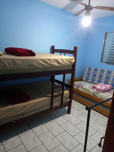 a room with two bunk beds and a fan at Casa 50 mts da praia Caravelas PR com ventiladores in Matinhos