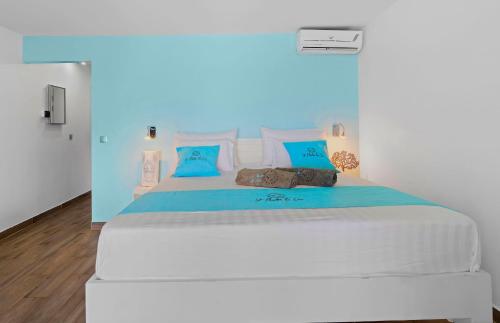 a bedroom with a large white bed with blue pillows at Beyond Seas Studio in Saint Martin