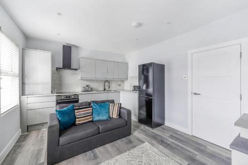 a living room with a couch and a kitchen at Elegant Croydon Apartment in London