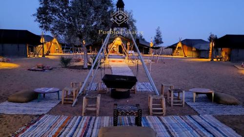 aented area with chairs and a grill and a tent at Pueblo Touareg - Private Tents in Merzouga