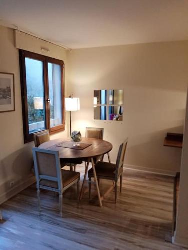 une salle à manger avec une table et des chaises et une fenêtre dans l'établissement Studio Cosy avec terrasse face au parc des expositions, à Vanves