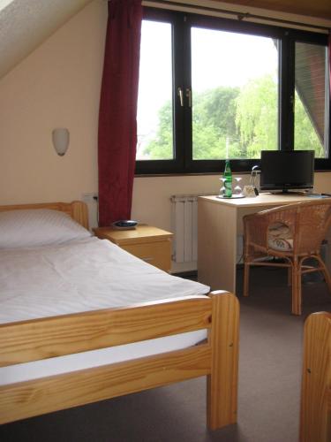 a bedroom with a bed and a desk with a computer at Hotel Haus Bergblick in Rheinbreitbach