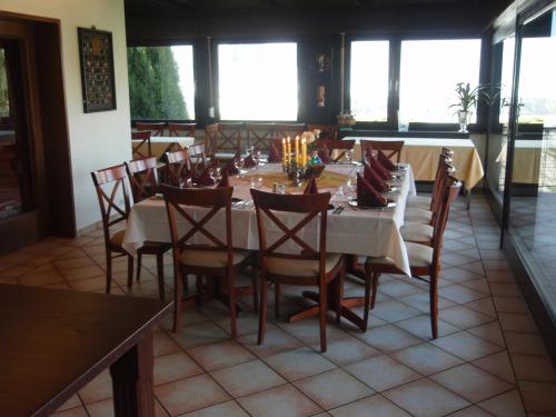 Hotel Haus Bergblick في Rheinbreitbach: غرفة طعام مع طاولة وكراسي ونوافذ
