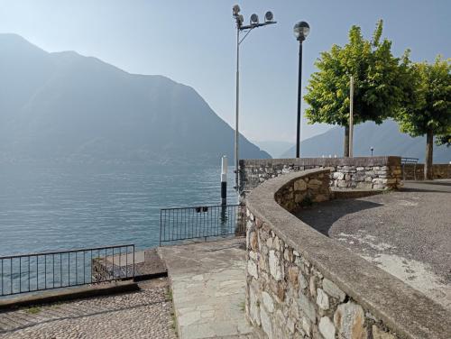 a stone retaining wall next to a body of water at Casa Violetta, Historic Center in Colonno