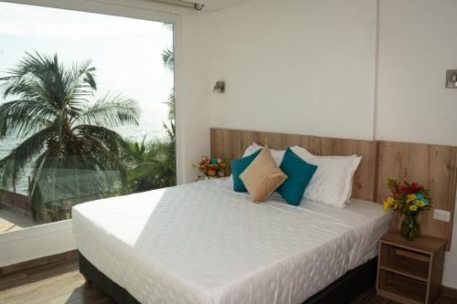 sypialnia z dużym łóżkiem z niebiesko-białymi poduszkami w obiekcie Hotel Caribbean Cartagena w mieście Cartagena de Indias