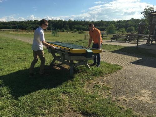 two men playing ping pong on a table in a park at Groepsaccommodatie - De Ooymanhoeve in Doetinchem