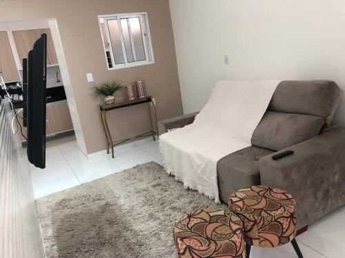 a living room with a couch and a tv at CASA PARA TEMPORADA CAMPINA GRANDE! in Campina Grande