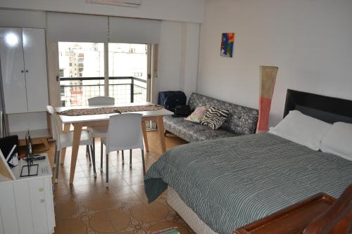 1 dormitorio con cama, mesa y sofá en buenos aires centro cerca de obelisco en Buenos Aires