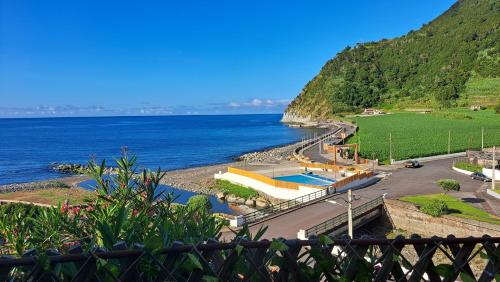a view of a body of water with a mountain at Villa de Bruma Faial da Terra in Faial da Terra