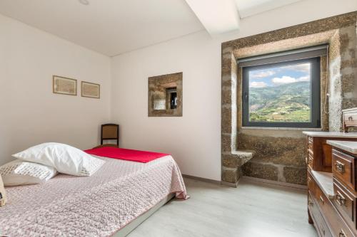 a bedroom with a bed and a large window at Quinta Barqueiros D'Ouro - Casa da Música in Mesão Frio