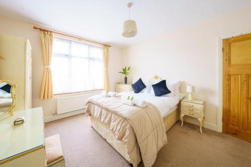 a bedroom with a large bed and a window at Wembley Arch View, 4-Bed House, Drive for 2 cars in London