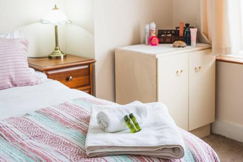 a bedroom with a bed with a towel on it at Wembley Arch View, 4-Bed House, Drive for 2 cars in London
