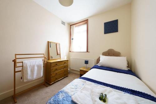 a bedroom with a bed and a mirror and a dresser at Wembley Arch View, 4-Bed House, Drive for 2 cars in London