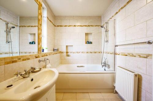 a bathroom with a tub and a sink at Wembley Arch View, 4-Bed House, Drive for 2 cars in London