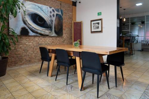Casa Corazon في غواذالاخارا: طاولة وكراسي خشبية في غرفة بها لوحة