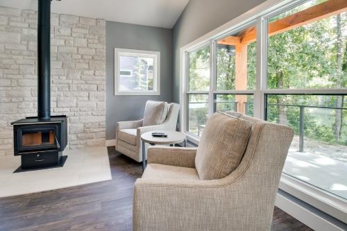 a living room with two chairs and a fireplace at Modern Norfork River Cabin Rental with Shared Dock! in Norfork