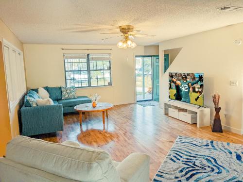 uma sala de estar com um sofá e uma mesa em Sun & Fun 3BR Beach Home with Pool & Tiki Bar em Jacksonville