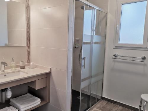 ein Bad mit einer Dusche und einem Waschbecken in der Unterkunft Chambres d'hôtes GIDY in Gidy