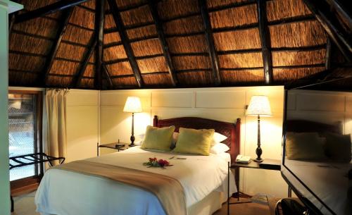 una camera da letto con un letto fiorito di Cresta Marang Gardens Hotel a Francistown