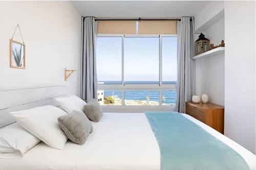 a bedroom with a large bed with a large window at Apartamento en Candelaria in Candelaria