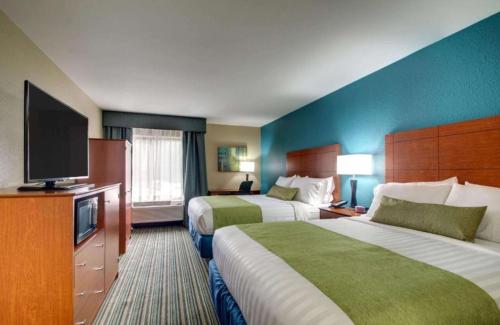 Habitación de hotel con 2 camas y TV de pantalla plana. en Best Western Eagles Inn, en Morehead