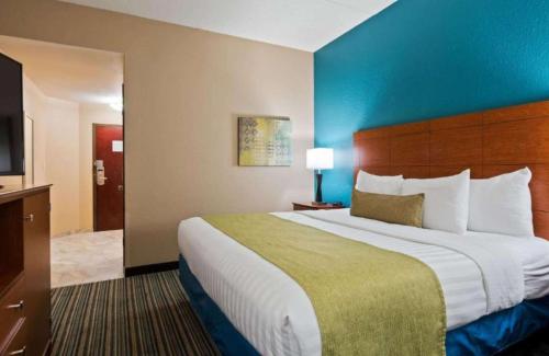 a hotel room with a large bed and a television at Best Western Eagles Inn in Morehead