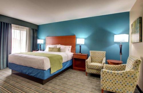 a hotel room with a bed and a chair at Best Western Eagles Inn in Morehead