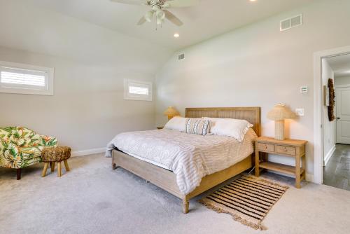 a bedroom with a bed and a chair and a fan at Sleek Long Branch Vacation Rental with Yard and Patio! in Long Branch