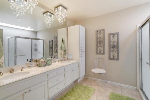 a bathroom with a sink and a mirror and a chair at Palm Desert Vacation Rental with Pool Access! in Palm Desert