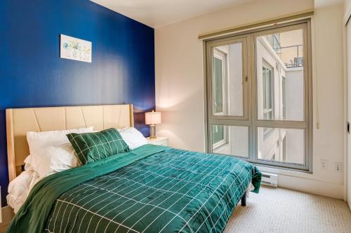 a bedroom with a bed with blue walls and a window at San Francisco Condo Less Than 1 Mi to Union Square! in San Francisco