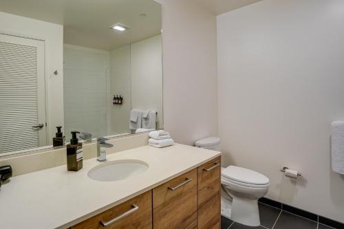 a bathroom with a sink and a toilet and a mirror at San Francisco Condo Less Than 1 Mi to Union Square! in San Francisco