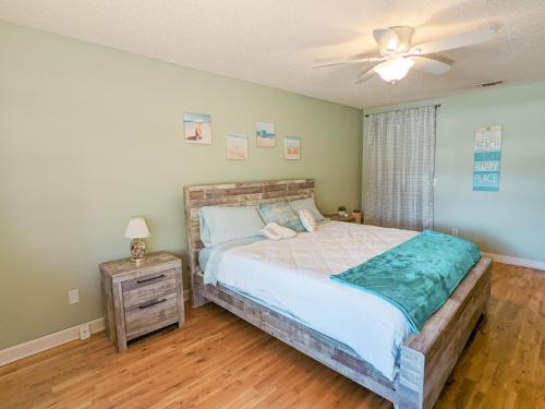 - une chambre avec un lit et un ventilateur de plafond dans l'établissement Sun & Fun 3BR Beach Home with Pool & Tiki Bar, à Jacksonville