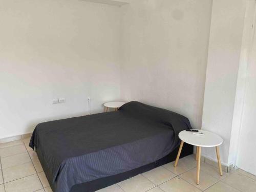 ein kleines Schlafzimmer mit einem Bett und zwei Tischen in der Unterkunft Depa privado en Guadalupe, céntrico y cómodo. in Monterrey