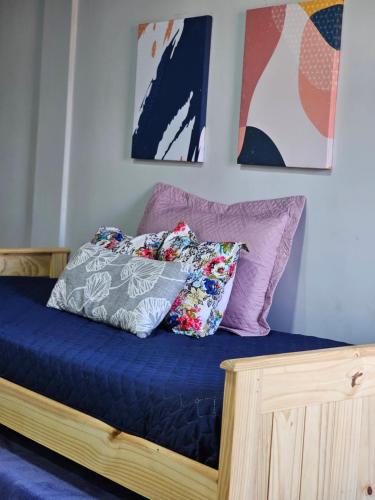 Una cama con sábanas azules y almohadas. en Apart Samambaia en Puerto Iguazú