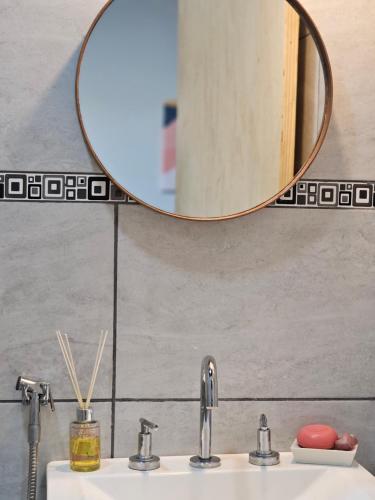 a bathroom sink with two faucets and a mirror at Apart Samambaia in Puerto Iguazú