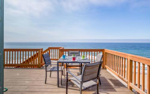 a table and chairs on a deck overlooking the ocean at Anchors Aweigh in Lincoln City