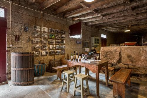 a bar with a wooden table and two stools at Quinta Barqueiros D'Ouro - Casa da Música in Mesão Frio