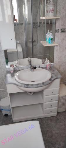 a bathroom with a white sink and a mirror at Star Vega 66 in Benidorm