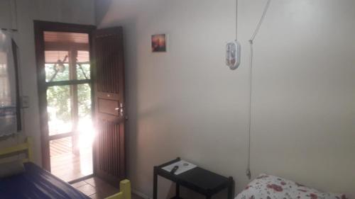 1 dormitorio con una puerta que conduce a un porche en Pousada Tia Tina, en Paranaguá