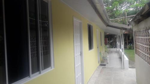 a hallway of a house with yellow walls and a door at Pousada Tia Tina in Paranaguá