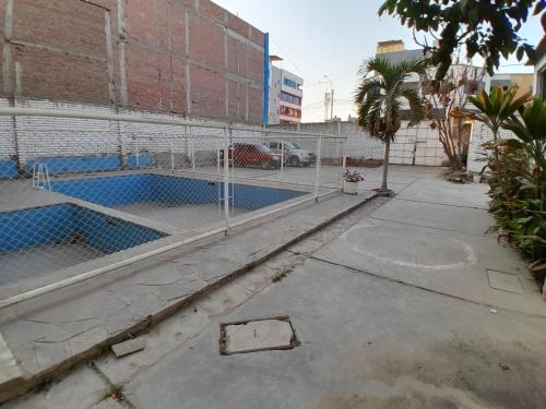 une piscine vide à côté d'une clôture dans l'établissement Hotel el Sol, à Chiclayo