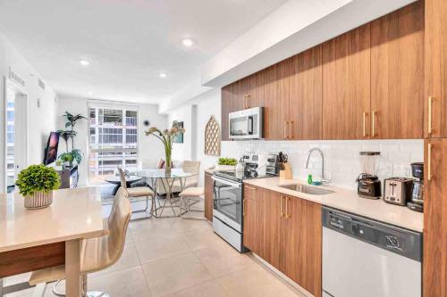 a kitchen with wooden cabinets and a table in it at Modern Unit in Downtown Miami With Free Parking in Miami