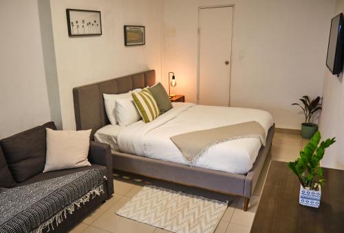 a small bedroom with a bed and a couch at The Pelican Poshtel in San Juan